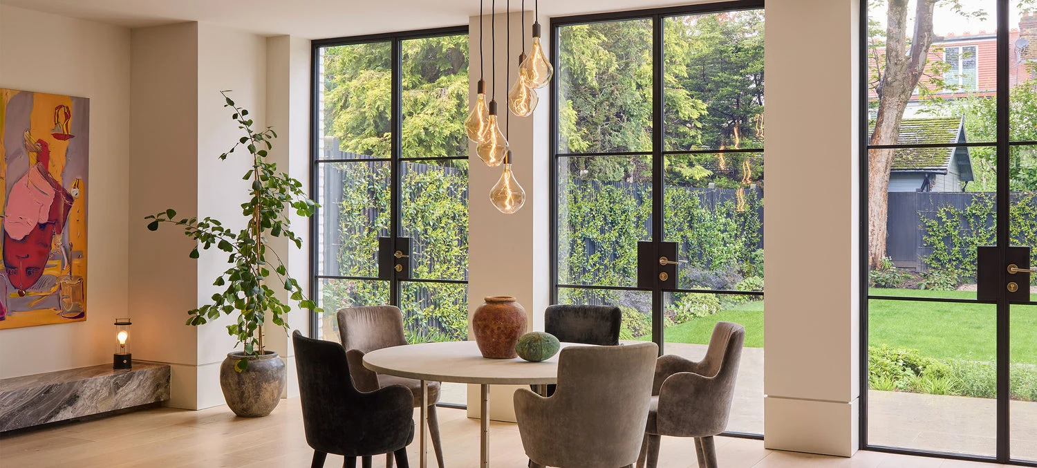 Pendant lights above a dining table in a sunlit interior